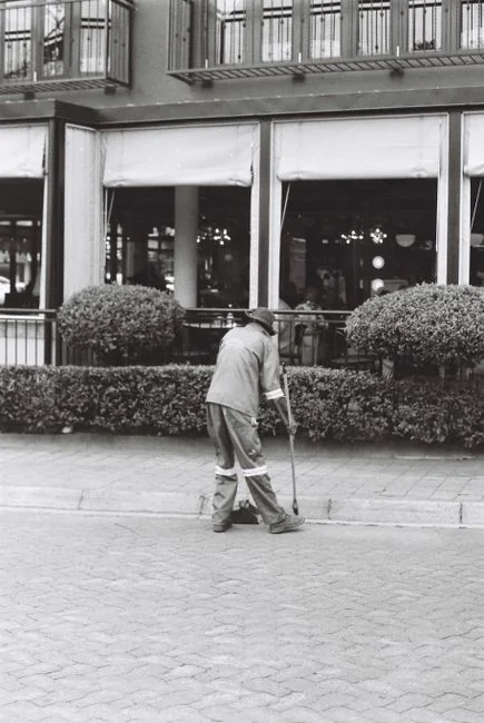 An adult male cleaning a glass window indoors, focusing on household chores and cleanliness.